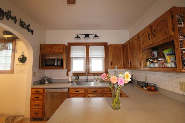 kitchen featuring stainless steel dishwasher, sink, and tasteful backsplash