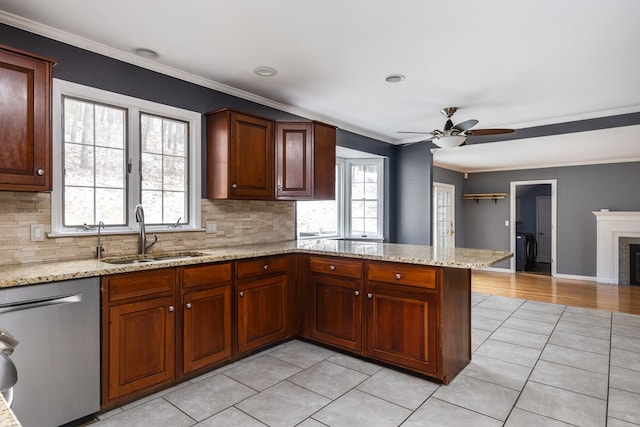 kitchen featuring sink, ceiling fan, ornamental molding, light tile patterned flooring, and stainless steel dishwasher