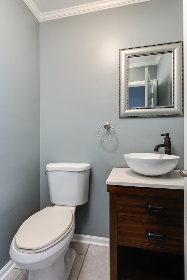 bathroom with tile patterned flooring, vanity, crown molding, and toilet