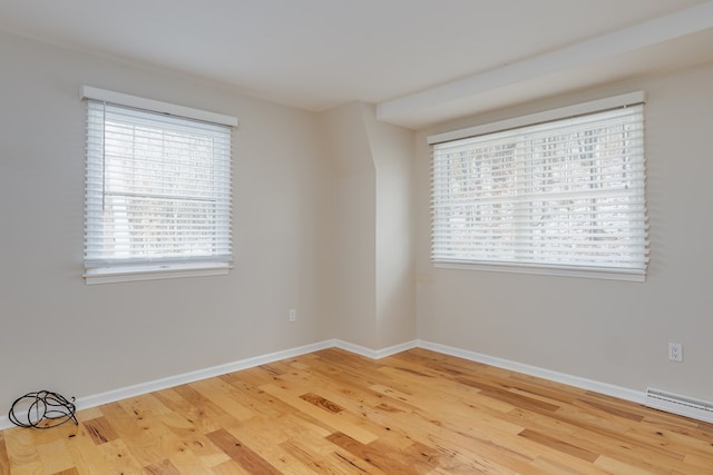 empty room with wood-type flooring and a healthy amount of sunlight