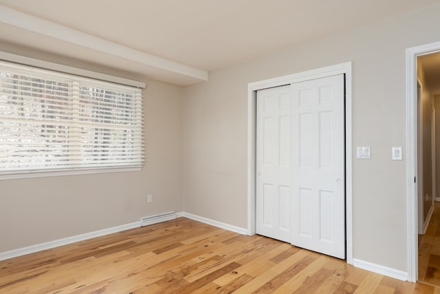 unfurnished bedroom with light hardwood / wood-style flooring and a closet