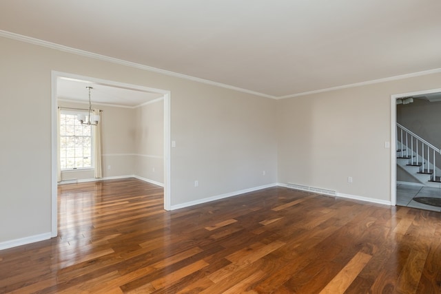 spare room with an inviting chandelier, crown molding, and dark hardwood / wood-style floors