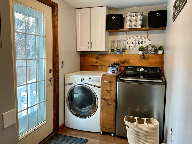 laundry room with light hardwood / wood-style floors, cabinets, washer and dryer, and a wealth of natural light