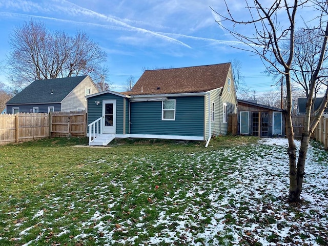 snow covered rear of property with a lawn