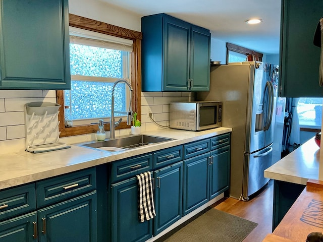 kitchen with sink, dark wood-type flooring, appliances with stainless steel finishes, and tasteful backsplash