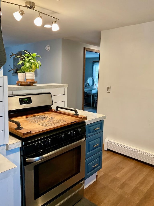 kitchen featuring a baseboard heating unit, stainless steel gas stove, blue cabinets, and light hardwood / wood-style flooring