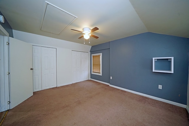 unfurnished bedroom with carpet floors, vaulted ceiling, ceiling fan, and multiple closets