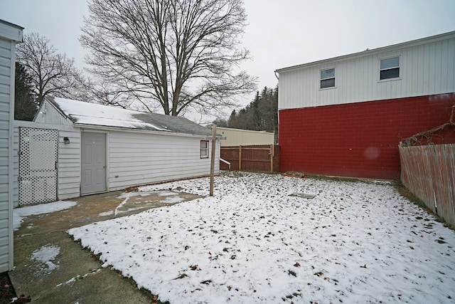 yard layered in snow featuring an outdoor structure