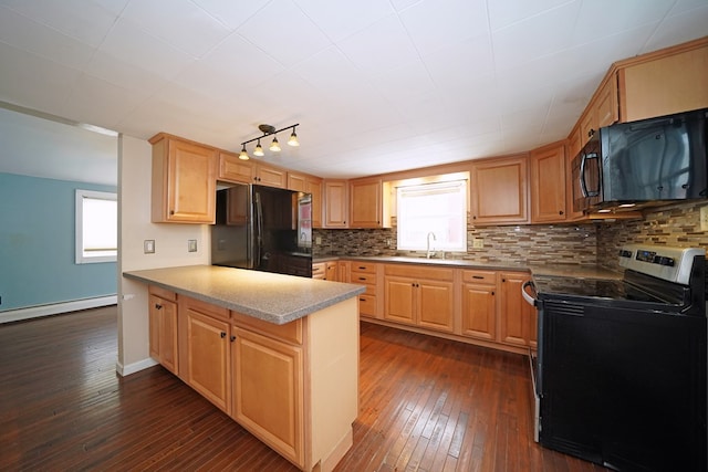 kitchen featuring black appliances, plenty of natural light, kitchen peninsula, and baseboard heating