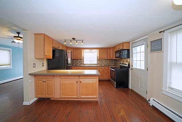 kitchen featuring backsplash, dark wood-type flooring, black appliances, baseboard heating, and kitchen peninsula