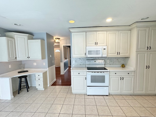 kitchen featuring white cabinetry, white appliances, tasteful backsplash, and light tile patterned flooring