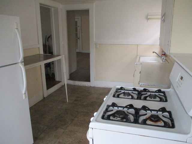 kitchen featuring white cabinets, sink, and white appliances