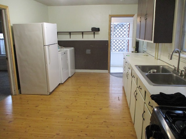 kitchen featuring white fridge, black range, sink, light hardwood / wood-style flooring, and white cabinets