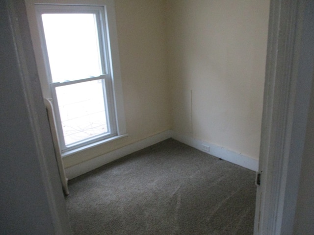 unfurnished room featuring dark carpet