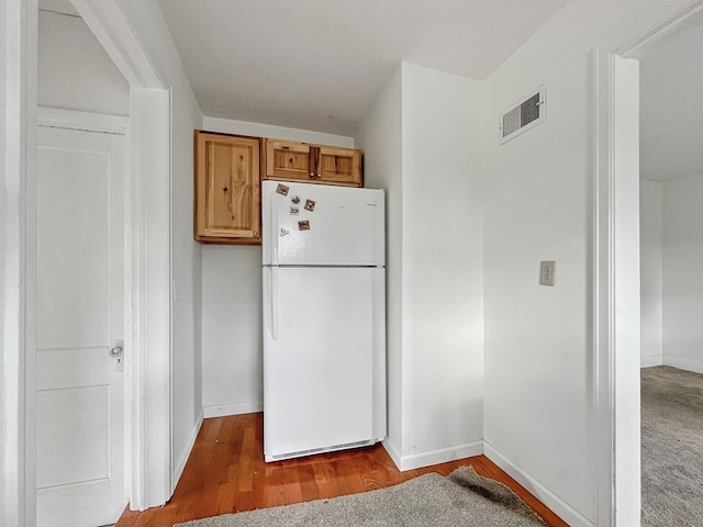 kitchen with hardwood / wood-style flooring and white fridge