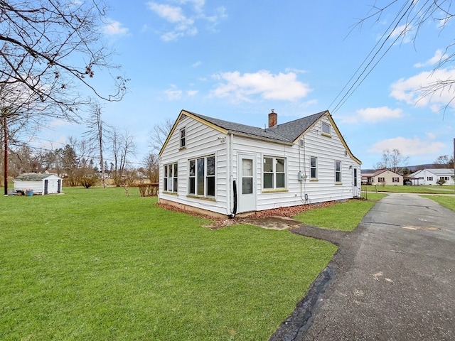 view of property exterior with a yard and a storage shed