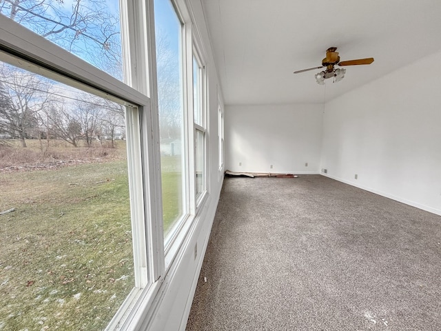 interior space with ceiling fan and dark carpet