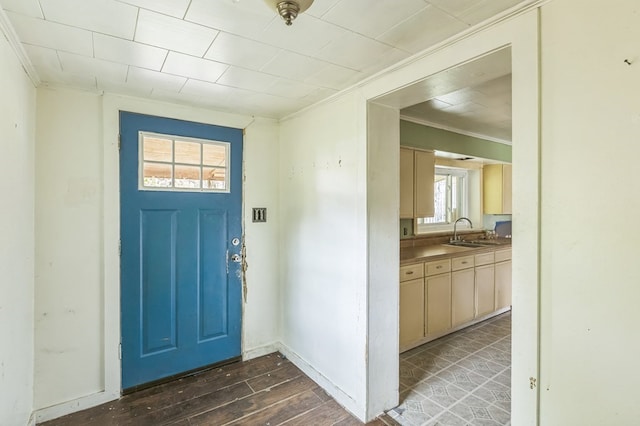 foyer entrance featuring dark wood-style floors, baseboards, and crown molding