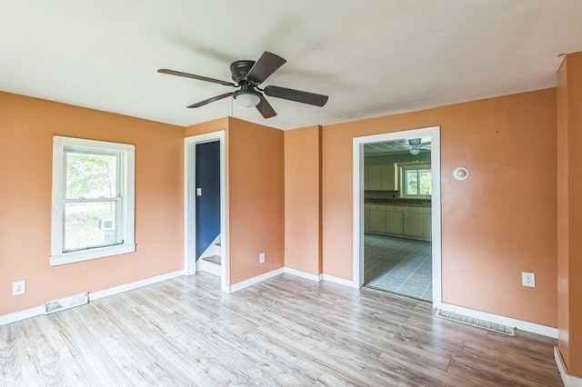 spare room with light wood-style floors, baseboards, stairs, and visible vents