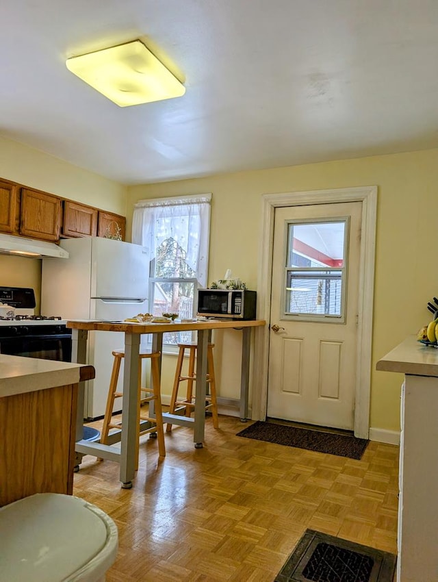 kitchen with white appliances and light parquet flooring