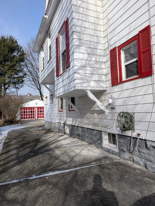 view of property exterior featuring a garage and an outbuilding