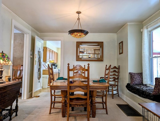 dining area with light carpet and crown molding