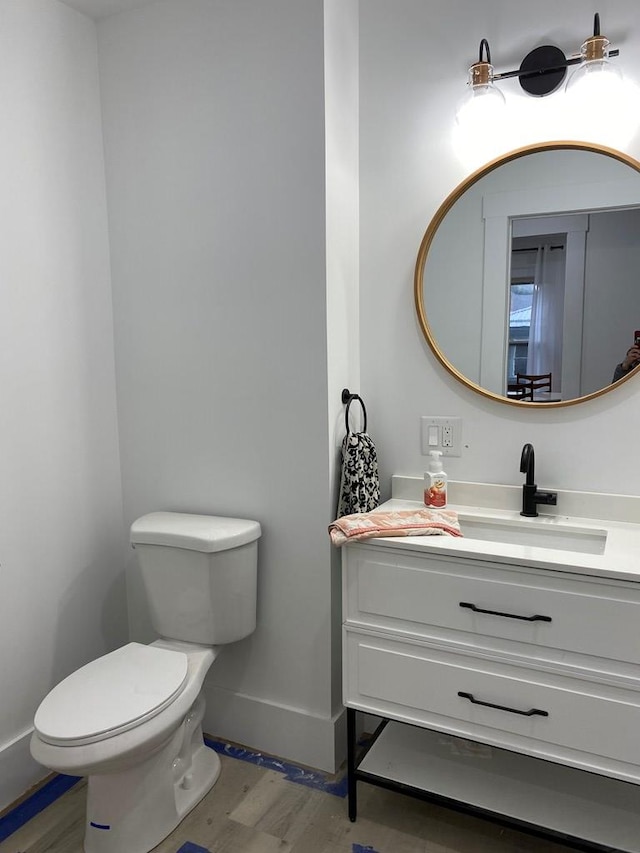 bathroom with hardwood / wood-style flooring, vanity, and toilet