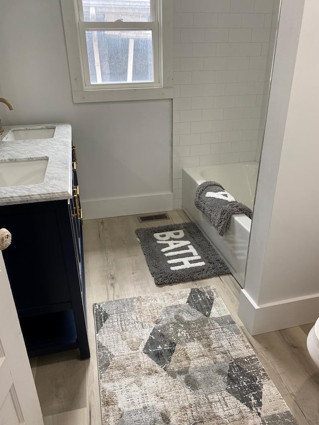 full bathroom featuring hardwood / wood-style flooring, vanity, toilet, and shower / washtub combination