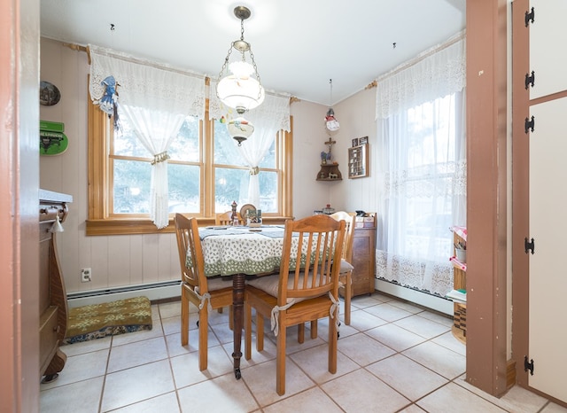 tiled dining area with a baseboard heating unit