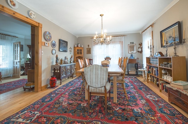 dining space featuring a notable chandelier, light wood-type flooring, and ornamental molding