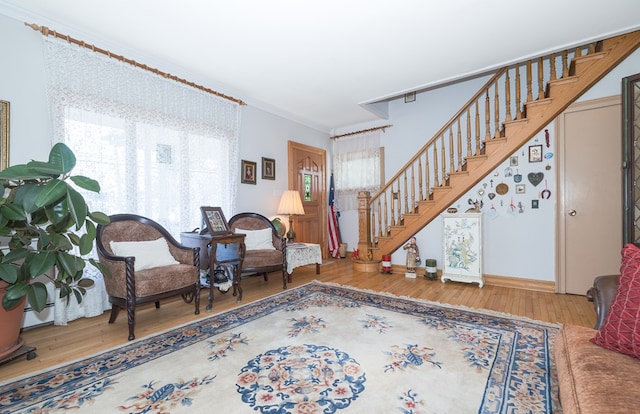 living area featuring hardwood / wood-style floors and ornamental molding