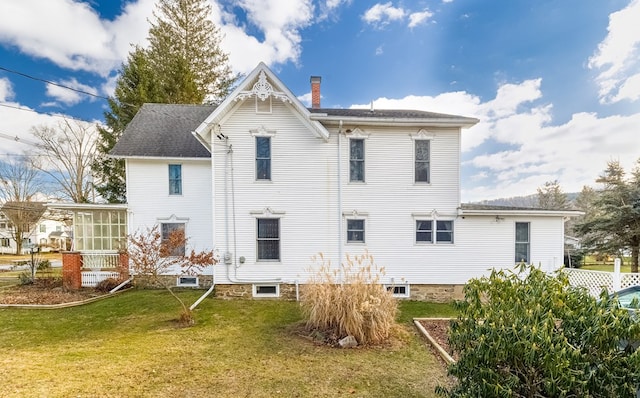 back of property featuring a yard and a sunroom