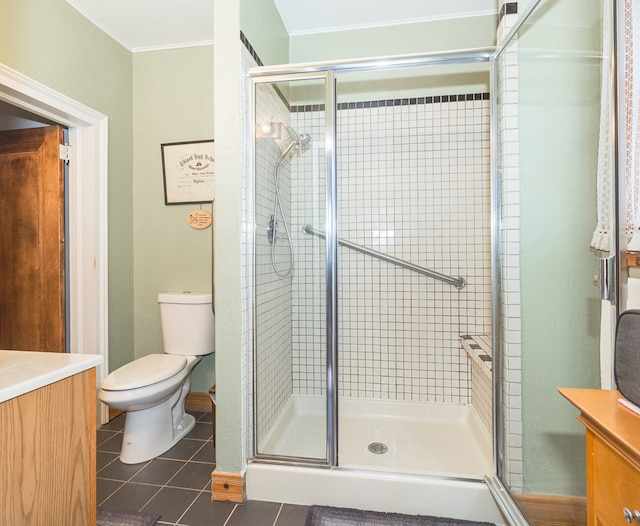 bathroom with tile patterned flooring, vanity, toilet, and an enclosed shower