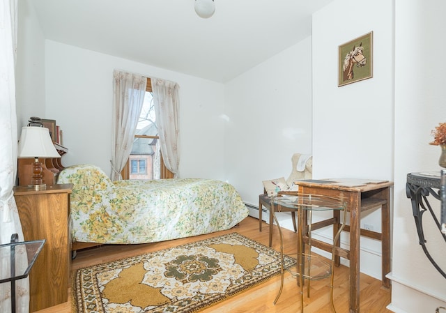 bedroom featuring wood-type flooring and baseboard heating