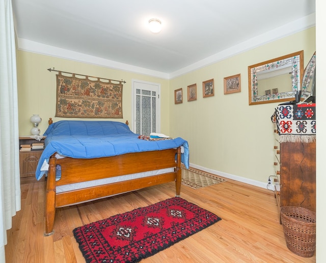 bedroom featuring crown molding and wood-type flooring