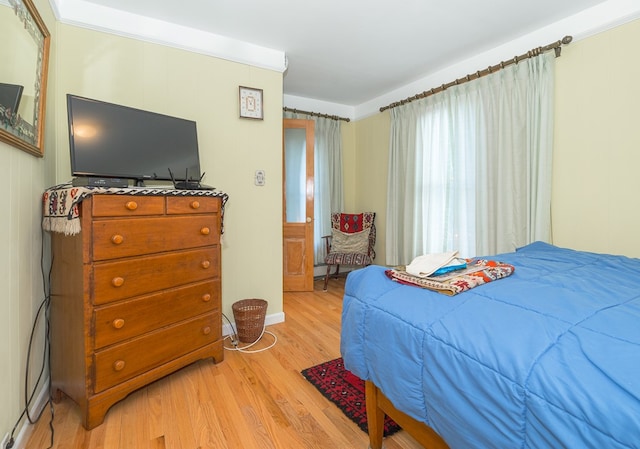 bedroom with light wood-type flooring and ornamental molding