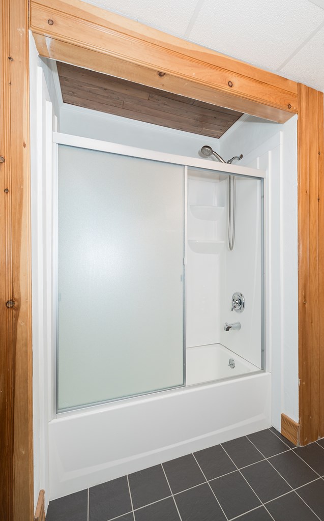 bathroom featuring tile patterned floors and enclosed tub / shower combo