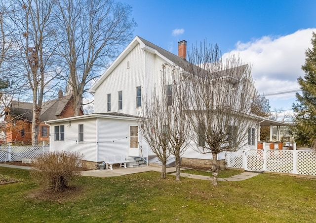 rear view of property featuring a lawn