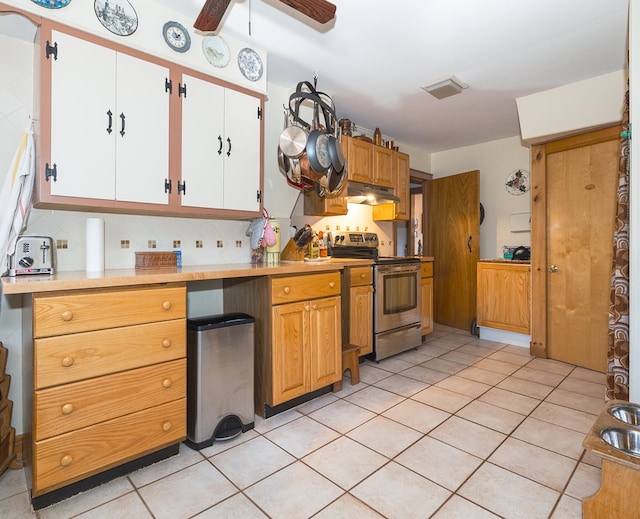 kitchen featuring decorative backsplash, stainless steel range with electric stovetop, ceiling fan, light tile patterned floors, and white cabinetry