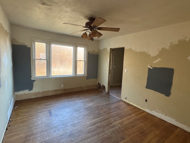 spare room with dark hardwood / wood-style flooring and ceiling fan