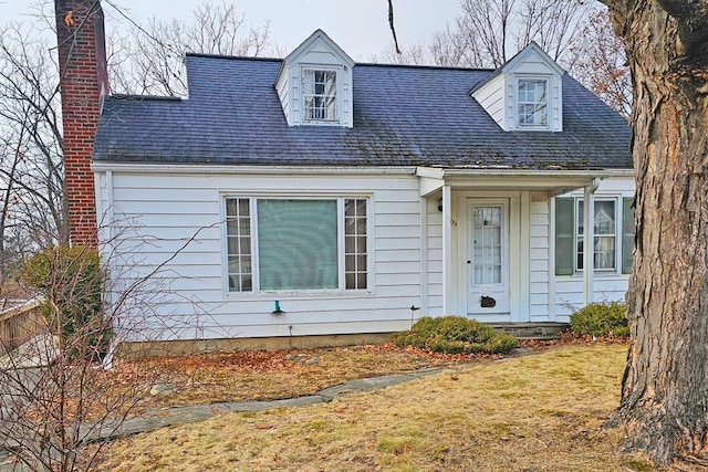 cape cod home with a front yard