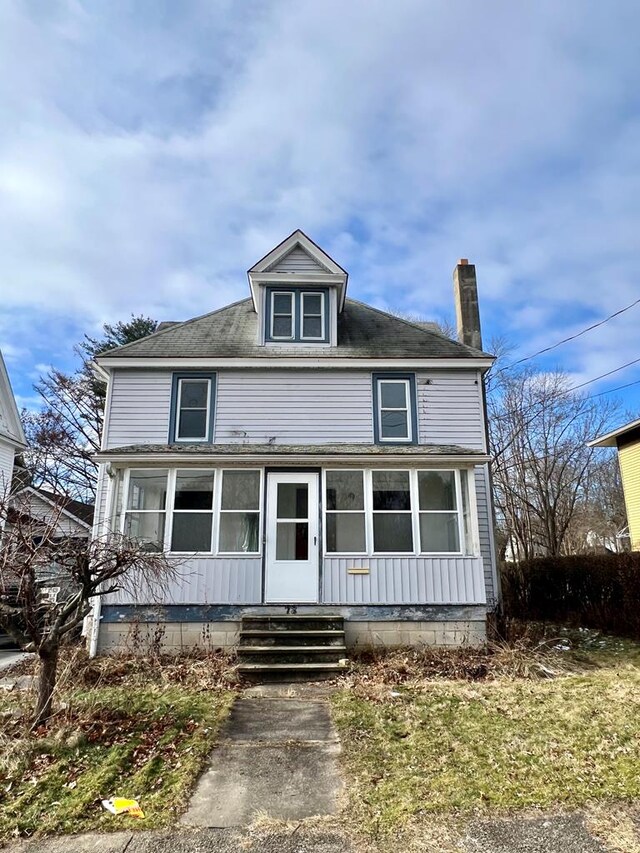 view of front of property with a front lawn and a sunroom