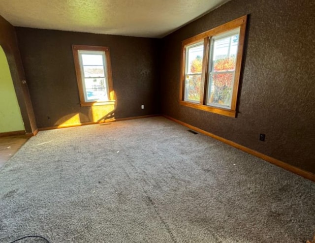 carpeted spare room featuring a textured ceiling