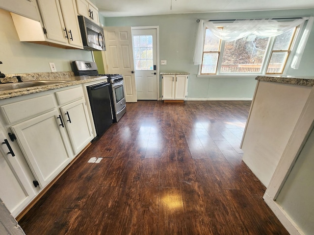 kitchen featuring dark hardwood / wood-style flooring, sink, stainless steel appliances, and white cabinets