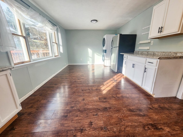 kitchen featuring dark wood-type flooring, stainless steel fridge, and white cabinets