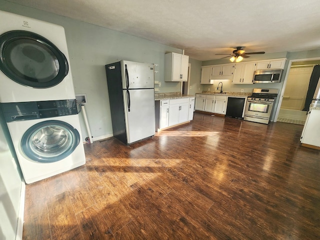 kitchen featuring dark wood-type flooring, appliances with stainless steel finishes, stacked washer and clothes dryer, a textured ceiling, and white cabinets