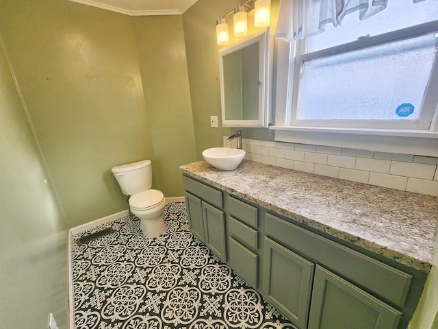 bathroom with backsplash, tile patterned flooring, vanity, ornamental molding, and toilet