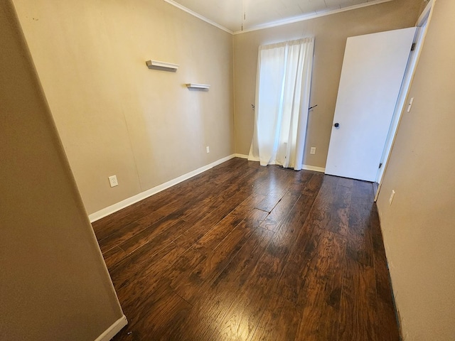 spare room featuring crown molding and dark hardwood / wood-style floors