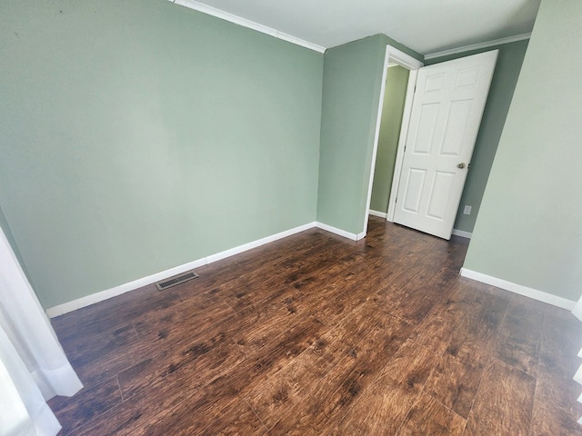 empty room with ornamental molding and dark hardwood / wood-style floors