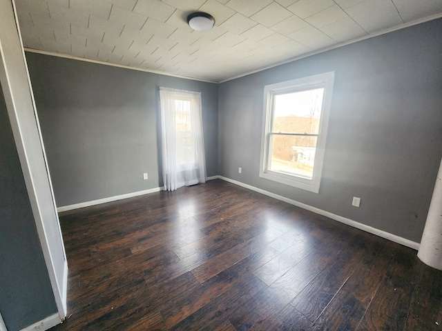 unfurnished room with a wealth of natural light, ornamental molding, and dark hardwood / wood-style floors